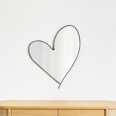 a heart shaped mirror hanging on the wall