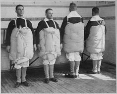 four men in aprons standing next to each other