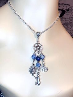 This beautiful chain necklace is the perfect way to express your affinity for the Greek goddess Hera.Pendant is made with a pentacle charm, and three symbols of the goddess:PeacockCowLotus3 genuine sodalite beads and one lapis lazuli bead also make up the pendant.Available in a variety of lengths. Secured with a lobster clasp that can fit in any of the links on the chain, making it easily adjustable.Made from zinc alloy. All materials are lead and nickel free.Comes in a jewelry box so it’s ready Bohemian Jewelry With Round Sodalite Beads, Spiritual Dangle Charm Necklace With Adjustable Chain, Spiritual Dangle Necklaces With Moon Charm, Spiritual Crystal Necklace With Adjustable Chain And Dangle, Bohemian Sodalite Necklace As Gift, Spiritual Moonstone Nickel-free Necklace, Spiritual Nickel-free Moonstone Necklaces, Nickel-free Moonstone Spiritual Necklace, Spiritual Healing Crystal Necklace With Lobster Clasp