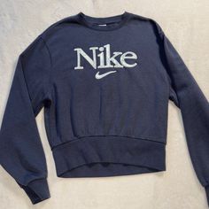 In Brand New Condition. A Nike Logo Appliqu In Crushed Velvet Adorns A Cozy Fleece Sweatshirt In A Slouchy, Cropped Silhouette For Trendy Style. 20" Length (Size Xs) Crew Neck Long Dolman Sleeves Pullover Style Front Embroidered Logo Appliqu Knit Construction Fleece Interior Ribbed Trim Cropped Body: 52% Cotton, 30% Rayon, 18% Polyester; Rib: 49% Rayon, 47% Cotton, 4% Spandex Machine Wash Cold, Tumble Dry Nike Letter Print Top For Winter, Nike Tops With Letter Print For Winter, Nike Blue Crew Tops, Nike Tops With Letter Print For Fall, Blue Fleece Tops With Letter Print, Nike Blue Tops For Fall, Dream Outfits, Trendy Style, Fleece Sweatshirt