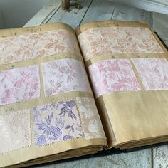 an open book with many different colored papers on top of it, sitting on a wooden table