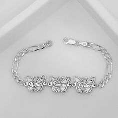 "STERLING SILVER BUTTERFLY FAMILY NAMES."  Metal: Solid 925 Sterling Silver.  Chain type Bracelet: Figaro Diamond Cut.   Clasp Link: Lobster Claw lock.  Thickness Chain: 4.8 mm.  Butterfly sizes each Name:18 mm Wide X 14 mm Hight.  This type of Family ID butterfly Bracelet its deep engrave names and figaro chain is makes great for everyday wear.  This Personalized style with custom charm makes a stunning statement Bracelet.  Can customize this jewelry with any family name of your choice and also determine the size of the bracelet in order to ensure that it is perfectly fitted on your wrist. Will be made with the same kind of typography that is shown in the image. This fine piece of jewelry is made with real Solid 925 Sterling Silver, (we do not use any coating or plated metal on our jewelr Engraved Sterling Silver Bracelet, Sterling Silver Bracelet With Engraving Option, Sterling Silver Butterfly Bracelet, Silver Sterling Silver Butterfly Bracelet, Butterfly-shaped Sterling Silver Bracelet, Silver Sterling Silver Name Charm Bracelet, Engraved Sterling Silver Name Bracelet In Silver, Sterling Silver Butterfly Bracelets, Silver Butterfly Bracelet For Gift