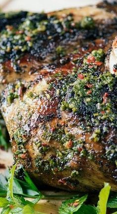 a piece of meat covered in herbs on top of a cutting board with parsley