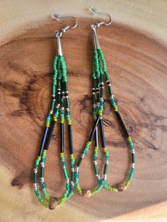 Handmade/ native made beaded earrings. Czech beads size 10/11 in different shades of green and silver bead accents, buggle glass beads, silver in color cones and hooks and juniper berries. Total length 5". Juniper berries are used in many different Native American tribes. The Interior Salish and Northwest Coast tribes used juniper to banish evil spirits and protect themselves. They are often called ghost beads. Banish Evil Spirits, Juniper Berries, Green And Silver, Different Shades Of Green, Northwest Coast, Native American Tribes, Beading Projects, Evil Spirits, Silver Bead