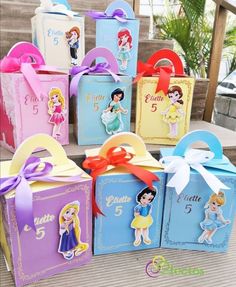 several boxes with princesses on them and ribbons tied around the top, sitting on some steps