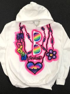 "This listing is for a White Airbrushed Hooded Sweatshirt with artwork on the front. 50/50 blend. *Sizes run small, It is recommended to size up. TO ORDER: Enter Name, Design Number and any Color Changes under \"Personalization\" Kids Sizes: X-Small (4/5) Small ( 6/8) Medium (10/12) Large (14/16) X-Large (18/20) Adult sizes also available. Sizes Small and Medium. *Heat Pressed to preserve artwork* DEFAULT DESIGN IS THE PRIMARY PHOTO ON THE LISTING. If you would like what is shown on the first ph Fun Graphic Print Hoodie For Streetwear, Fun Graphic Print Hoodie Sweatshirt, Casual Hoodie With Custom Artwork For Streetwear, Casual Sweatshirt With Custom Artwork For Streetwear, Airbrush Ideas, New York Party, Design Number, Painted Clothes, Name Design