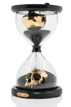 an hourglass with sand and a skull in it on a white background, isolated