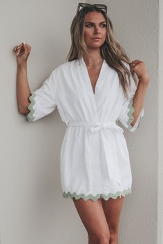 The perfect little kimono when heading anywhere sandy. White short sleeve kimono style dress, green trim detail on hems, adjustable tie belt at waist Material is Polyester Hang to dry Model is 5’9 wearing a small SHOP THE LOOK Small Medium Large Length 33” 34” 35” Bust 21” 22” 23” Summer Beach Kimono With Belt, Summer Daywear Belted Kimono, Summer Belted Kimono For Daywear, Chic Summer Belted Kimono, Chic Summer Kimono With Belt, Chic Belted Summer Kimono, Summer Daywear Kimono With Tie Waist, Summer Kimono With Tie Waist For Daywear, Spring Belted Kimono For Daywear