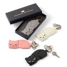 three keychains in different colors and designs are sitting next to each other on a white surface