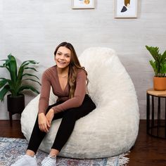 a woman is sitting on a bean bag chair