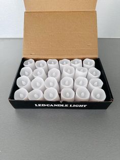 a box filled with white candles sitting on top of a table