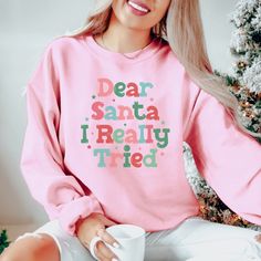 This cute, funny Christmas crewneck features the saying Dear Santa I Really Tried. This Holiday sweatshirt would make the perfect addition to any Christmas wardrobe.  www.etsy.com/shop/jadeandroseshop ❤️ Please note that for the oversized look you need to buy 1-3 sizes larger than you normally wear. If you prefer the standard Unisex fit order your typical size. For women, if you prefer a more women's fit sweatshirt please size down 1 size, as this sweatshirt is a Unisex fit ❤️ This unisex heavy Funny Winter Top With Text, Winter Funny Text Top, Winter Funny Style Top With Text, Casual Christmas Sweatshirt With Letter Print, Cute Winter Letter Print T-shirt, Holiday Cotton Sweatshirt With Letter Print, Holiday Crew Neck Sweater With Letter Print, Christmas Sweatshirt With Letter Print, Christmas Pink T-shirt With Letter Print