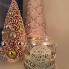 a candle next to a christmas tree on a shelf