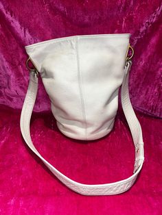 "D E S C R I P T I O N  Vintage 80s cream leather shoulder bag. Bag is a bucket shape, one main compartmen, and gold tone hardware.  M E A S U R E M E N T S Bag Length: 7.5\"  Bag Strap Drop: 18\"  Bag Depth: 7.5\"  Bag Height: 11.5\" Authenticity Guarantee  All bags sold in our shop are 100% guaranteed authentic or your money back." Leather Bucket Bag, Leather Bucket, P T, Bag Bag, Bag Straps, Purses And Handbags, Leather Shoulder Bag, Bucket Bag, 20 Cm