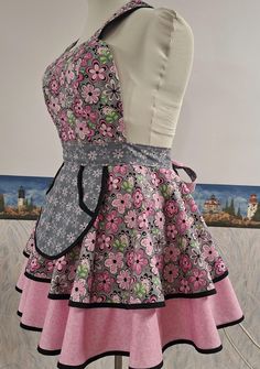 a mannequin wearing a pink and black dress with flowers on it's skirt