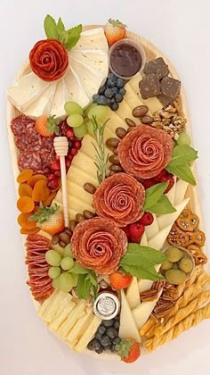 a platter filled with lots of different types of cheeses and fruit on top of each other