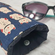 Large fabric sunglasses case with a cute waving cat print makes a great home for your oversized sunglasses.  The outer fabric is a Japanese bamboo cotton and has a lovely texture, giving it a luxury feel. With it's all over print on a navy base this is a classic colour combo with a cute print making it perfect for everyday use.  SIZE (approx)  - The opening of our regular glasses case is 8cms / 3 inch. The large cases have an 11cms / 4.5 inch.  All our glasses cases are padded throughout giving Waving Cat, Sunglasses Storage, Padded Pouch, Black Tissue Paper, Navy Base, Japanese Bamboo, Glasses Cases, Cat Themed Gifts, Brand Stickers