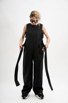 Who's the freshest of them all? It's you in the Black linen jumpsuit women! This sleeveless jumpsuit features, sides cut out, tie waist belt included, two front pockets and flowy wide leg pants. This linen clothing is designed to flatter every body type. When we designed this Black linen jumpsuit women, we focus on the versatility of each model to make it a perfect match for your favorite accessories and wardrobe pieces. Perfect for slaying in the streets, pair this Black overalls women with a l Black Jumpsuits And Rompers With Side Pockets For Summer, Sleeveless Summer Overalls With Side Pockets, Black Cotton Jumpsuit For Summer, Black Relaxed Fit Wide Leg Jumpsuits And Rompers, Sleeveless Black Overalls For Spring, Black Linen Jumpsuits And Rompers For Summer, Summer Wide Leg Jumpsuits And Rompers With Relaxed Fit, Summer Wide-leg Relaxed Fit Jumpsuits And Rompers, Spring Wide-leg Black Jumpsuits And Rompers