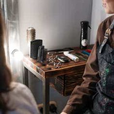 a woman sitting in front of a desk with keys on it