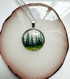 a glass pendant with trees on it