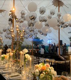 a table set up for an event with white and silver decorations