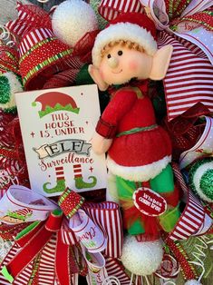 a christmas wreath with an elf holding a sign