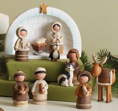 a group of figurines sitting on top of a green couch next to a christmas tree