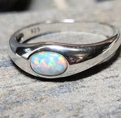 This is a white lab grown opal and sterling silver ring. The front of the ring is 1/4 of an inch tall. It retailed at $32. It comes in a jewelry box for gifting. Classic Opal Moonstone Ring As Gift, Silver Opal Birthstone Ring Gift, Nickel-free Opal Ring As Gift, Nickel-free Opal Rings As Gifts, Classic Adjustable Opal Ring For Anniversary, Classic Opal Birthstone Ring As Gift, Silver Opal Ring Gift, Nickel-free Silver Opal Ring For Anniversary, Opal Ring Gift