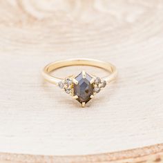 a close up of a gold ring with a stone in the middle on a wooden surface