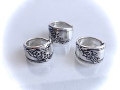 three silver rings with floral designs on them