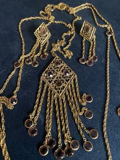 "Beautiful Etruscan Revival Goldette Filigree Necklace  with Matching Clip Style Dangle Earrings Unsigned. Fold over style clasp  Multi strand layered chain with bezel set crystal dangle accents  Very good Vintage condition with slight signs of use and wear  Measures approx Necklace 40\"L longest  Center pendant 5\"x2\"  Clip style earrings 3\"" Antique Gold Jeweled Earrings, Filigree Pendant Jewelry For Party, Antique Jeweled Jewelry For Formal Occasions, Ornate Filigree Jewelry For Evening, Costume Jewelry Pendant Earrings For Wedding, Wedding Pendant Costume Jewelry Earrings, Wedding Pendant Earrings Costume Jewelry, Antique Formal Jewelry, Wedding Pendant Costume Earrings