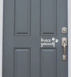 a gray door with the words grace yourself on it and a dog's paw