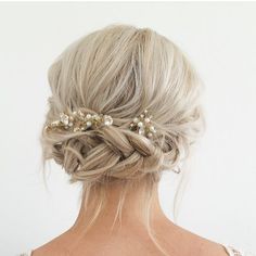 the back of a woman's head with braids and pearls in it