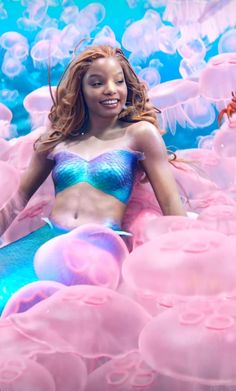 a woman laying on top of a blue and pink floaty surface with jellyfish