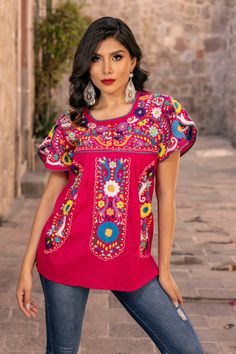 This Beautiful Hand embroidered blouse has a unique Mexican inspired Floral design and embroidered split sleeves. The blouse is a fresh cotton linen embroidered with cotton string. Paired with your favorite pair of jeans or a cute pair of shorts, the Floral Embroidered Camelia Top is a Solei favorite.  This distinctive embroidery design originated in Puebla, Mexico.  We have a deep appreciation for these beautiful works of art and the artisans who create them. With your help, we will support the Traditional Cotton Top With Embroidered Sleeves, Cotton Blouse With Embroidered Sleeves, Pink Short Sleeve Embroidered Cotton Top, Embroidered Crew Neck Cotton Blouse, Embroidered Cotton Crew Neck Blouse, Bohemian Cotton Tops With Machine Embroidery, Bohemian Cotton Blouse With Machine Embroidery, Cotton Folk Top With Embroidered Sleeves, Multicolor Embroidered Cotton Blouse