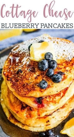 pancakes with blueberries and butter on top are stacked up in front of the camera