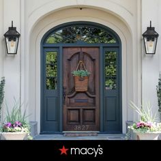 the front door to a home with potted plants on it and an entryway