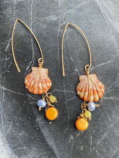 Sunset shell dangly earrings made with gold and pearls. Almost 3 inches long. One ear wire is damaged. Beautiful. Gold Pearl Drop Beaded Earrings, Gold Pearl Dangle Linear Earrings, Dangle Brass Pearl Earrings, Gold Pearl Shell-shaped Earrings, Gold Dangle Linear Earrings With Pearl Charm, Dangle Brass Earrings With Pearl Charm, Brass Dangle Earrings With Pearl Charm, Dangle Earrings With Pearl Charm In Brass, Gold Wire-wrapped Pearl Earrings