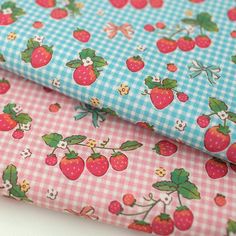 two different patterns of fabric with strawberries and flowers on them, one is blue and the other has pink gingham