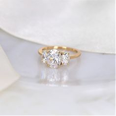 three stone diamond ring on white cloth