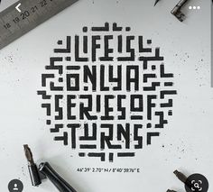 an image of some type of lettering on a white paper with scissors and pencils