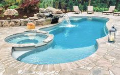 an outdoor pool surrounded by stone steps and patio furniture