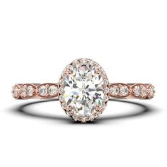 a rose gold engagement ring with an oval cut diamond in the center and pave set shoulders