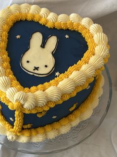 a blue and yellow cake with a white rabbit on it's face in the shape of a heart