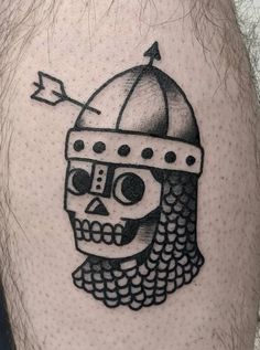 a man's leg with a skull wearing a helmet on it and an arrow in the