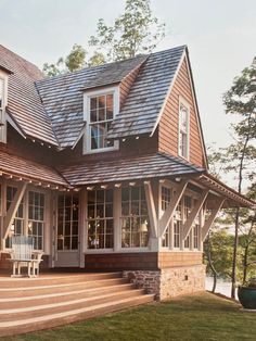 a large wooden house with a porch and stairs leading up to the front door area