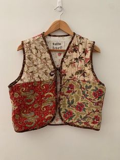 a vest hanging on a hanger with an image of flowers and leaves printed on it