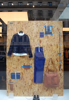 a display case in a store window with blue and brown items on the wall behind it