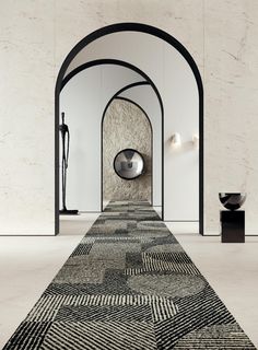 a long rug is on the floor in an empty room with white walls and black arches