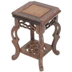 a small wooden table with an intricate design on the top and bottom, sitting against a white background